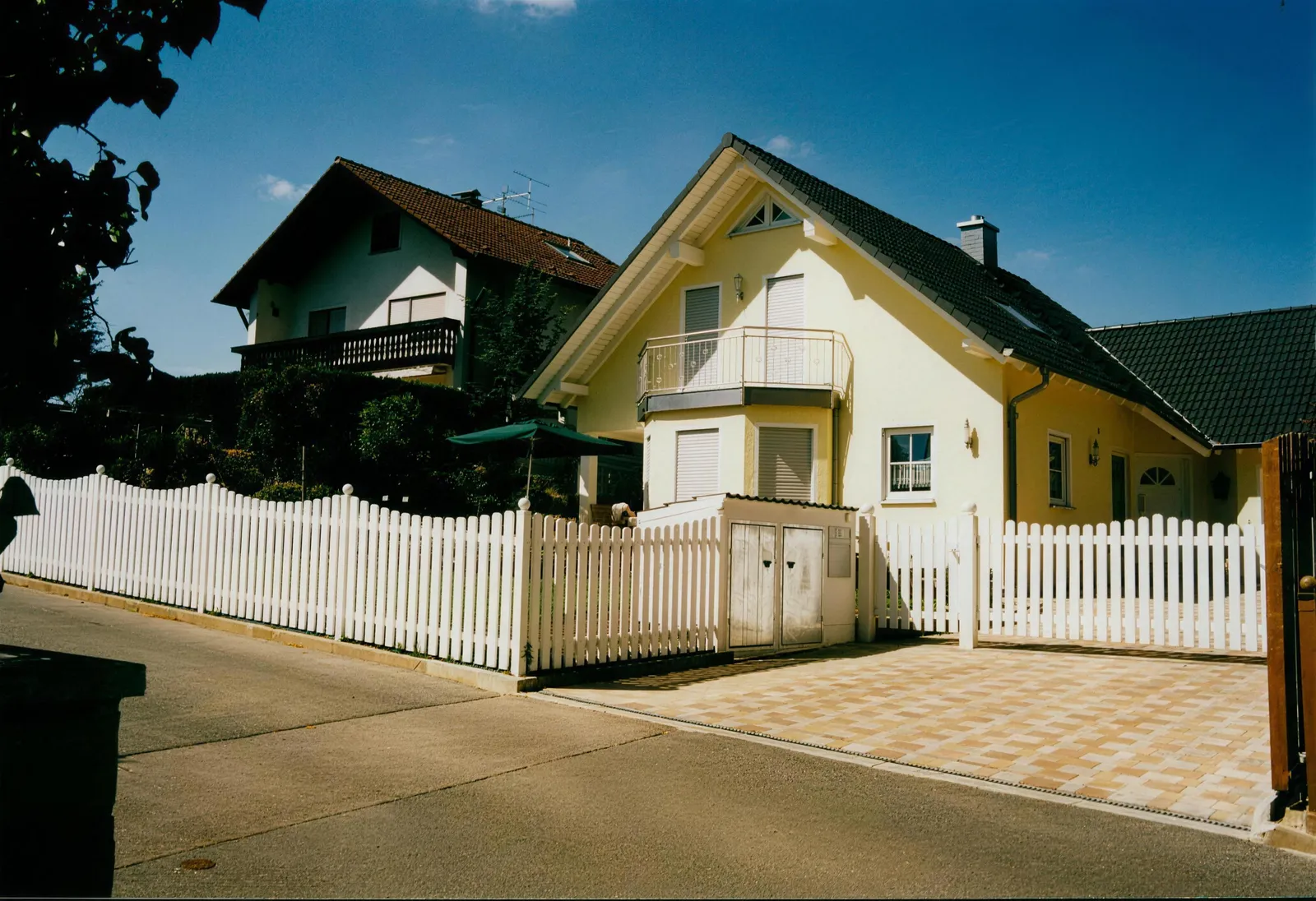 Weißer Schmuckzaun mit Tor an einem Wohnhaus, gefertigt von Draht-Hörl